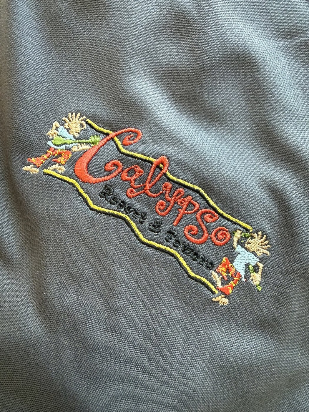 Close-up of colorful logo embroidery on grey fabric
